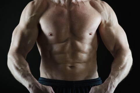 Muscular man flexing his muscles. Photo : Daniel Grill