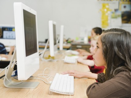 Children working at computers in classroom.