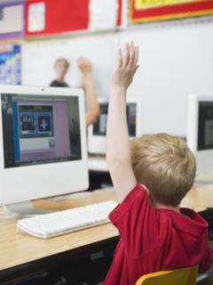 Student raising hand in classroom.