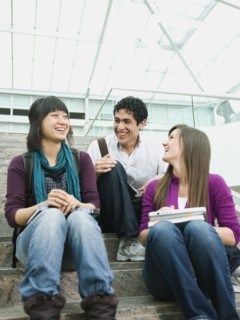 College students sitting on steps in front of library.