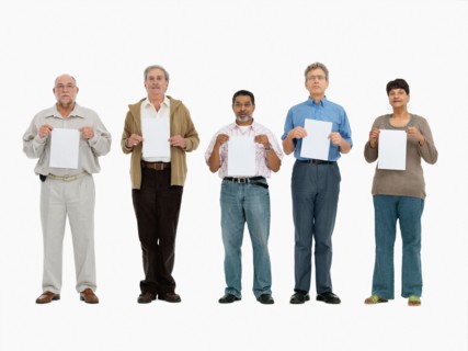 Group of people standing in a row holding papers. Photo : momentimages