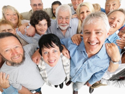 A group of people standing with their arms around each other. Photo : momentimages