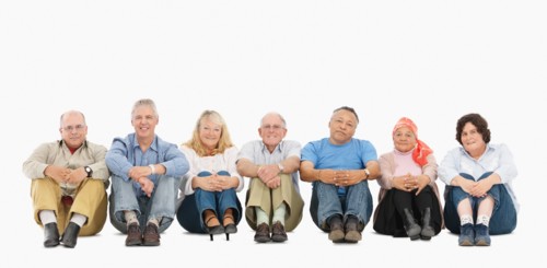 A group of people sitting on the floor in a row. Photo : momentimages
