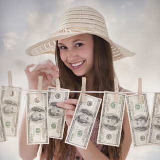 Woman hanging 100 dollar bills on clothesline. Photo : Mike Kemp