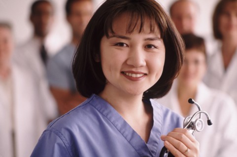 Portrait of a doctor with medical team in the background. Photo : Rob Lewine