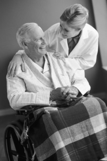 Doctor talking to senior man in wheelchair. Photo : Rob Lewine