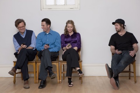 People sitting in row while holding cell phones. Photo : Dan Bannister