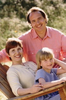Parents and their young daughter sitting in Adirondack chair. Photo : Rob Lewine