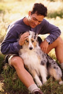 Man and his dog sitting on grass. Photo : Rob Lewine