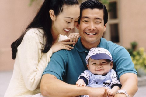 Happy parents sitting with their infant son. Photo : Rob Lewine