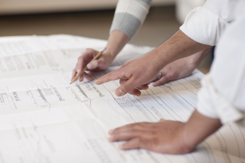 Hands pointing to a engineer's drawing. Photo : Dan Bannister