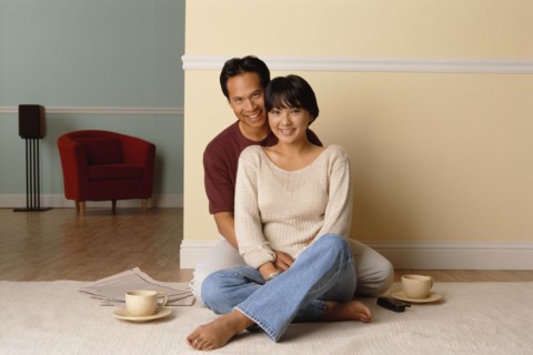 Happy couple sitting together on the floor in their home. Photo : Rob Lewine