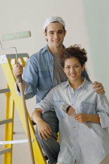 Happy couple painting the walls in their home. Photo : Rob Lewine