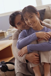 Happy couple sitting together on the floor in their home. Photo : Rob Lewine