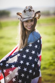 Beautiful cowgirl wrapped in American flag. Photo : Mike Kemp