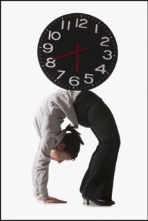 Clock on top of businesswoman bending over backwards. Photo : Mike Kemp
