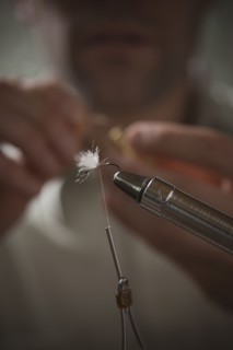 Man repairing fly fishing hook. Photo : Mike Kemp