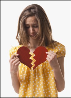Teenage girl holding broken heart. Photo : Mike Kemp