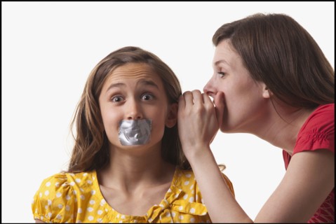 Woman whispering to a frightened girl. Photo : Mike Kemp
