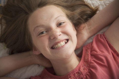 Young girl making cheesy smile. Photo : Mike Kemp