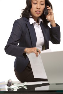 Businesswoman sitting on desk. Photo : K.Hatt