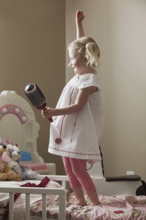 Young girl dancing on her bed. Photo : Mike Kemp