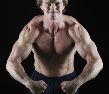 Muscular man flexing his muscles. Photo : Daniel Grill
