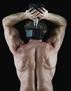 Man lifting free weight behind his head. Photo : Daniel Grill