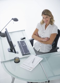 Confident businesswoman sitting at modern desk.