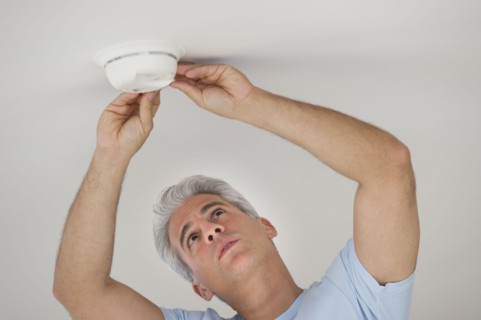 Man testing smoke detector.
