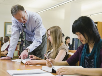 Professor giving instruction to college student.