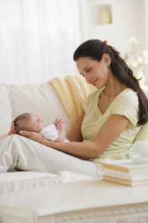 Mother sitting on couch with her baby.