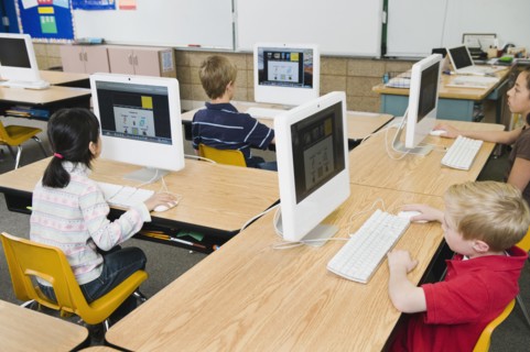 Children working at computers in classroom.