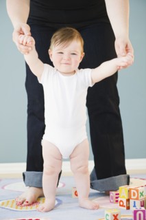 Toddler holding onto mother's hands. Photo : Jamie Grill