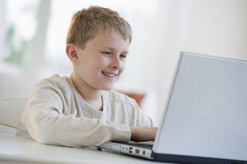 Young boy looking at laptop.