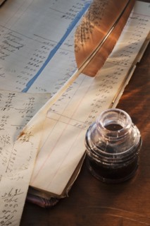 Ink feather pen and ledger.