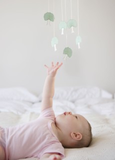 Baby playing with mobile. Photo : Jamie Grill