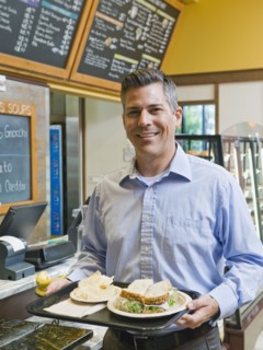 Man carrying sandwich on tray.