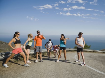 Runners stretching on a road in Malibu.