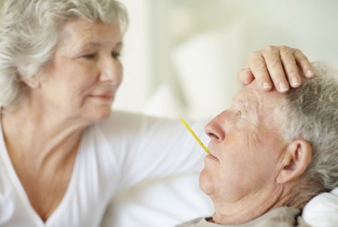 Senior woman caring for man with a fever. Photo : momentimages