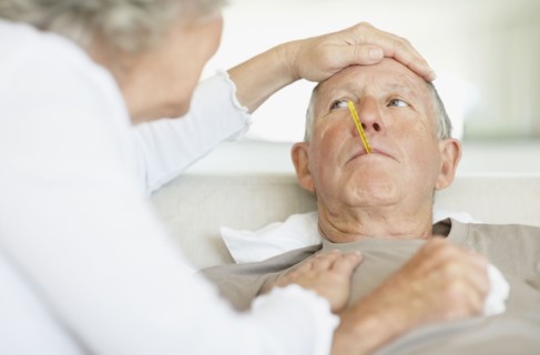 Senior woman caring for man with a fever. Photo : momentimages