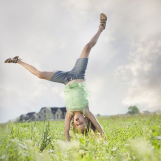Young girl doing cartwheel. Photo : Mike Kemp