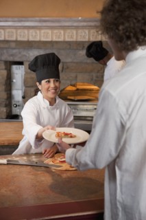 Pizza chef serving slice of pizza. Photo : Dan Bannister
