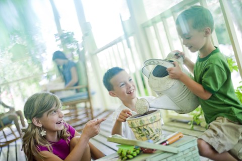 Young children watering seeds in a planter. Photo : Tim Pannell