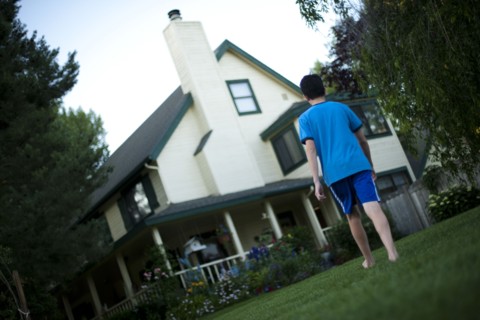 Young boy walking towards house. Photo : Tim Pannell