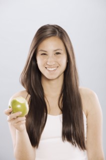Brunette woman holding an apple. Photo. FBP