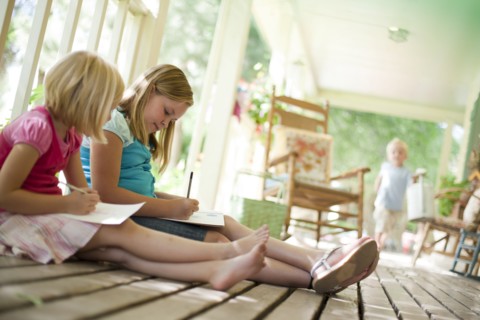 Two girls writing letters. Photo : Tim Pannell