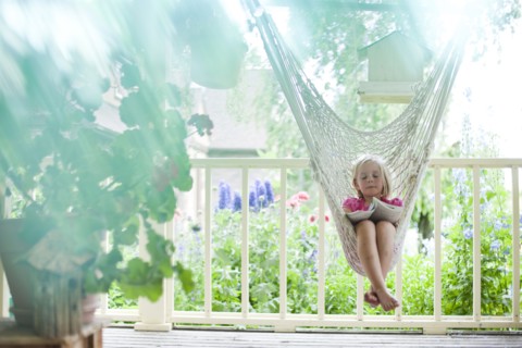 Young girl reading in hammock. Photo : Tim Pannell