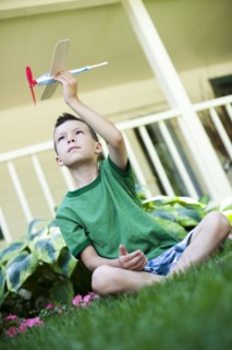 Young boy playing with toy airplane. Photo : Tim Pannell
