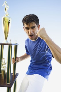 Football player holding trophy. Photo. Mike Kemp